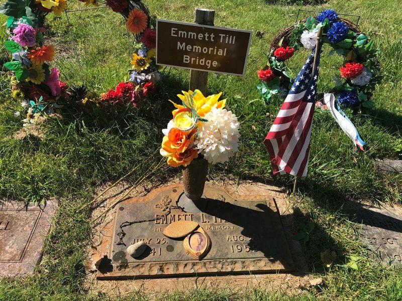 The headstone and the bridge sign. Till’s family placed this sign here to help identify the location of Till’s burial plot. Without this sign, the site blends in with hundreds of similar sites and can be difficult to locate.